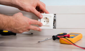 person's hand installing socket on wall